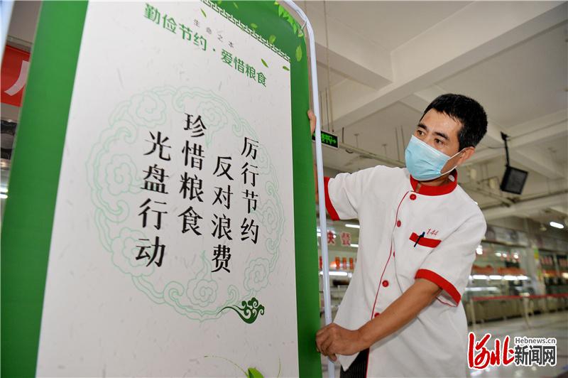 8月28日，河北师范大学工作人员在学校食堂内摆放倡导节约的宣传展板。