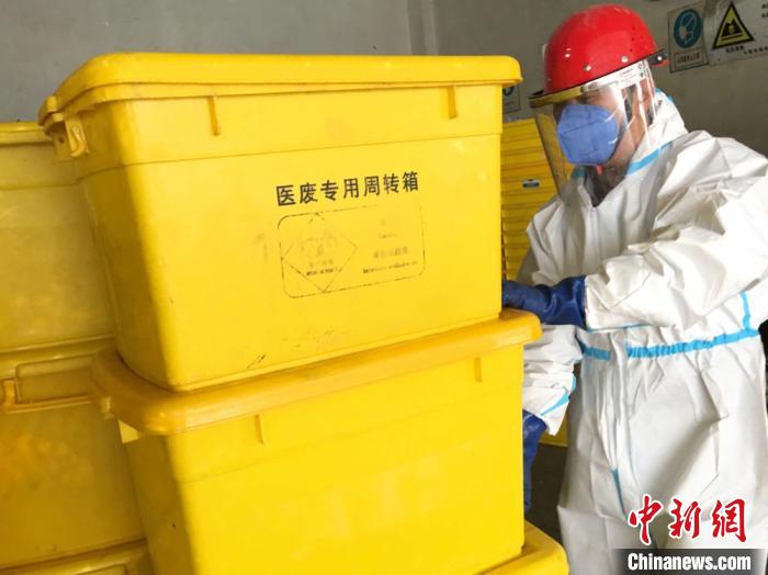 图为危险废物处置线上料岗位的霍宏德搬运医废专用周转箱。　张婧 摄