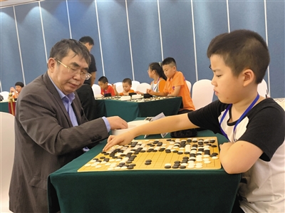 聂卫平指导青少年下棋。
