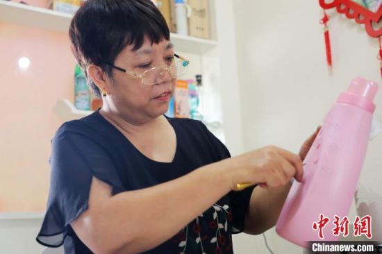 刘存芳剪刻废旧塑料桶。 姚友谅 摄