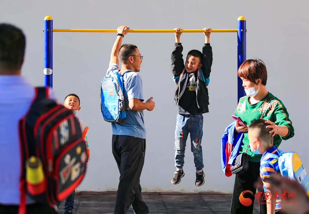 9月1日,在酒泉市西大街小学操场,一位小学生跳上单杠,大声喊道:爸爸看我棒不棒。