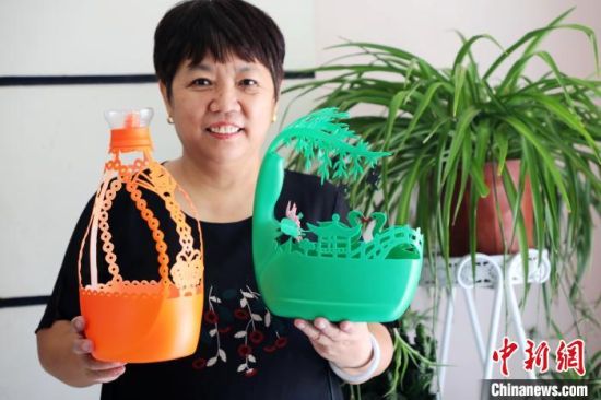 刘存芳展示变废为宝的手工艺品。 姚友谅 摄