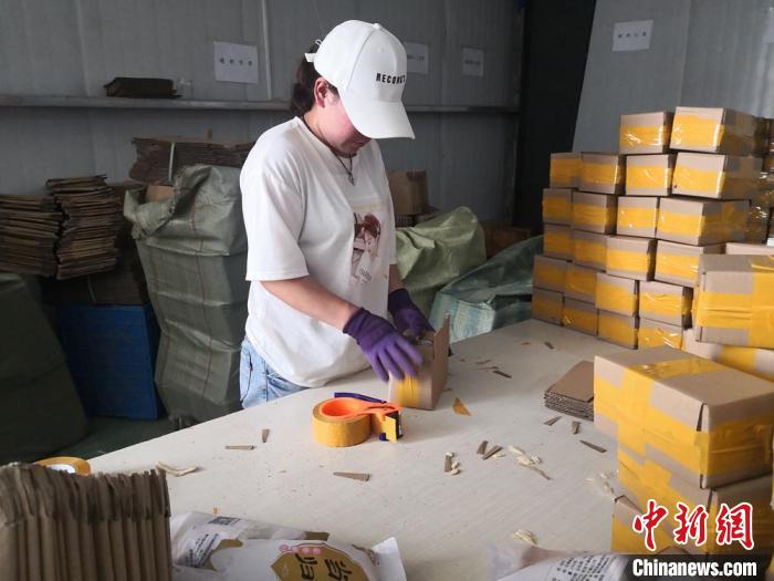 图为在甘肃聚和泰电子商务有限公司包装车间里工人打包药材　杜萍 摄