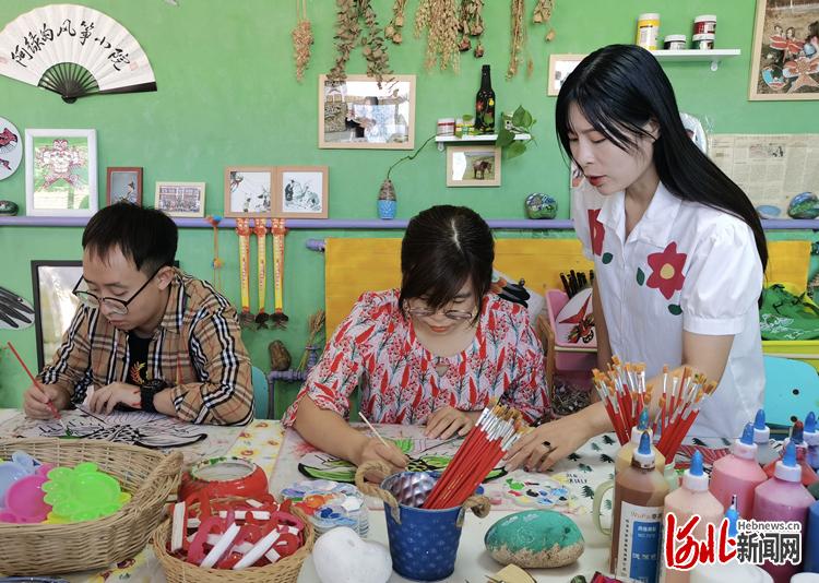 在第什里宗华风筝加工厂的风筝制作体验馆内，“90后”姑娘赵艳芳（右一）正带领游客体验传统风筝的制作过程。通讯员周禹佳摄