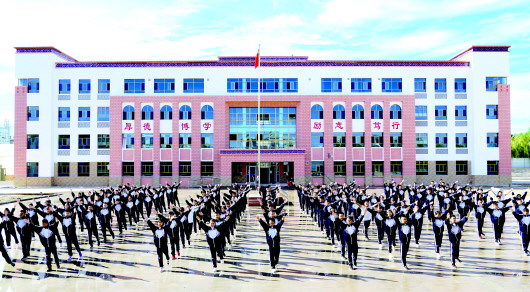 图为学生在新修建的教学楼前做课间操