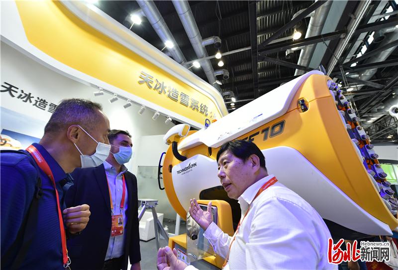 9月5日,天冰造雪设备(三河)有限公司工作人员(右一)在向客商介绍造雪机。当日,2020国际冬季运动(北京)博览会在北京开幕。 河北日报记者赵海江摄