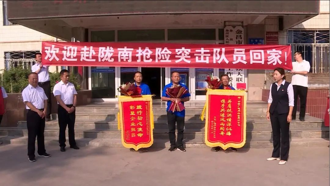 在甘肃广电网络金昌分公司门前，赴陇南市参与抢险救援的三名队员受到了公司的热烈欢迎。