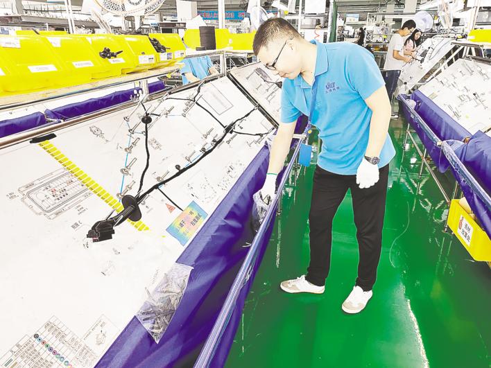 三贤电子科技有限公司生产车间工人正在进行汽车线束组装