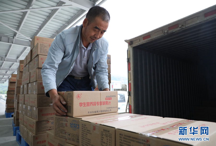 9月13日，工作人员王引田把在电商平台上销售的苹果汁装车。新华网（刘欣瑜 摄）