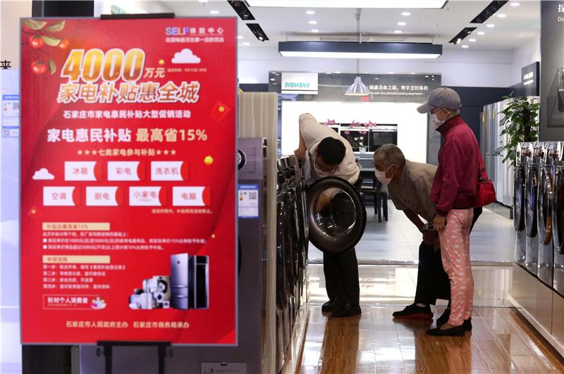 9月15日，在石家庄市桥西区一家电器综合市场，店员（左一）向顾客介绍家电产品。