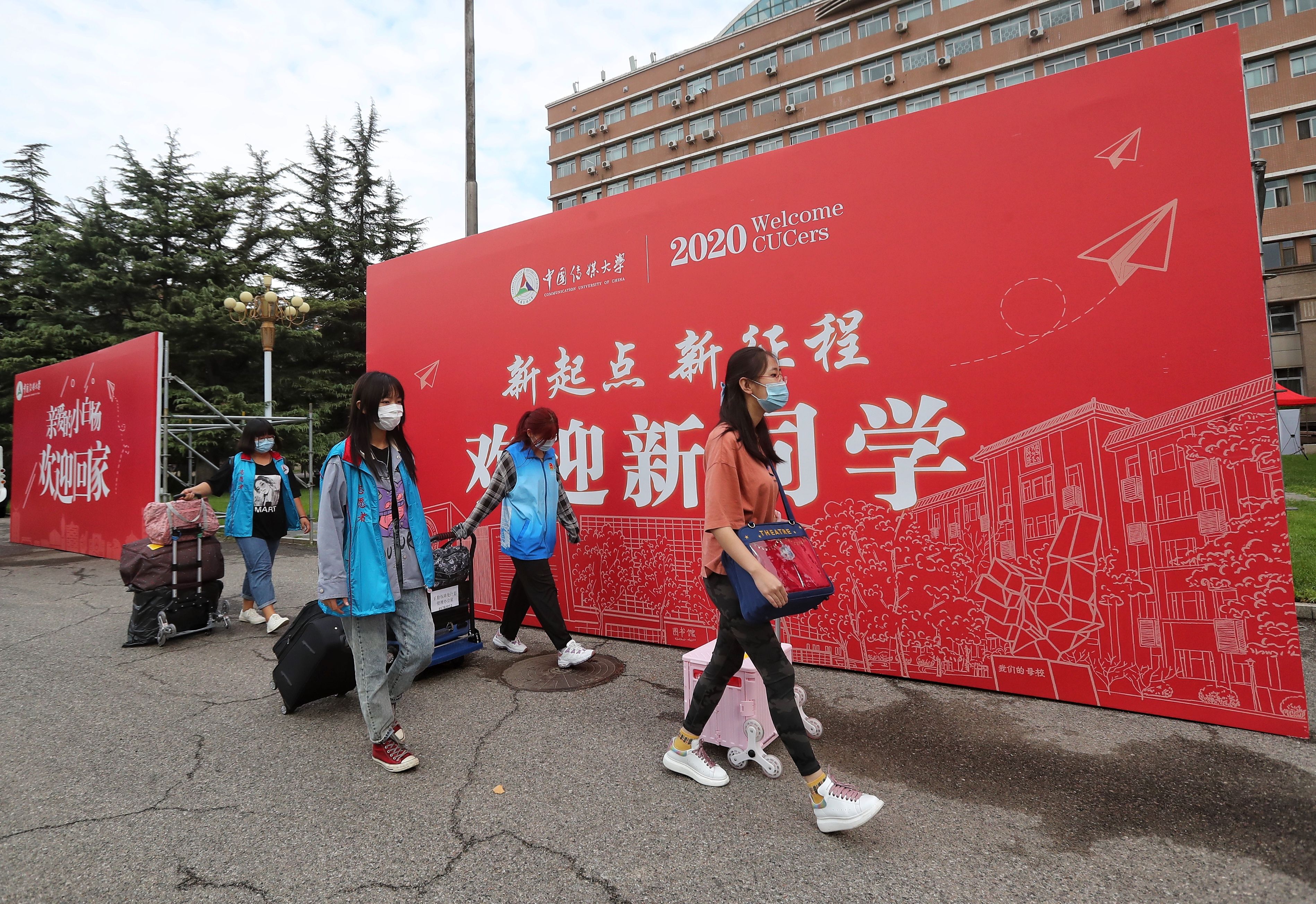 中国传媒大学新生报到的首日，穿着蓝马甲的志愿者用小推车帮助新生运送行李。新京报记者 王贵彬 摄