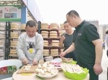9月9日,顾客在西和县展馆前品尝西和锅盔。本报见习记者 魏朵朵 摄
