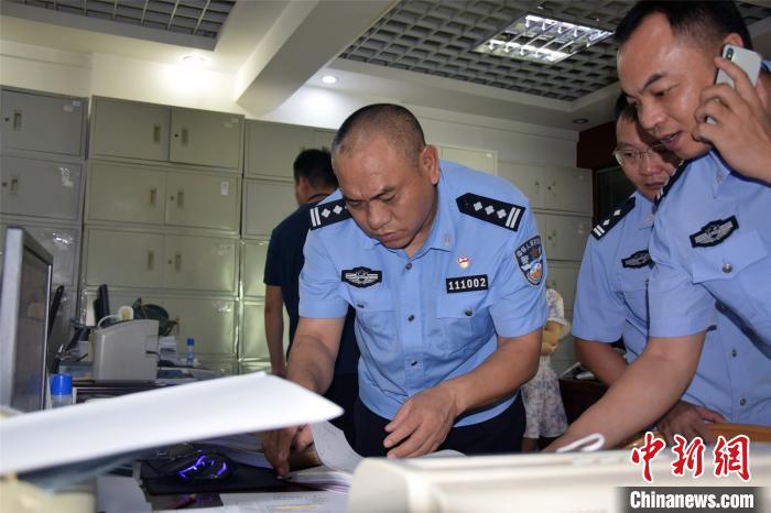 河源警方翻看缴获的虚假账本及材料。 源城警方供图