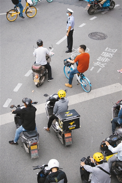 9月16日，在小寨十字，过往的摩托车驾驶员大多佩戴了头盔。 记者 张宇明 摄