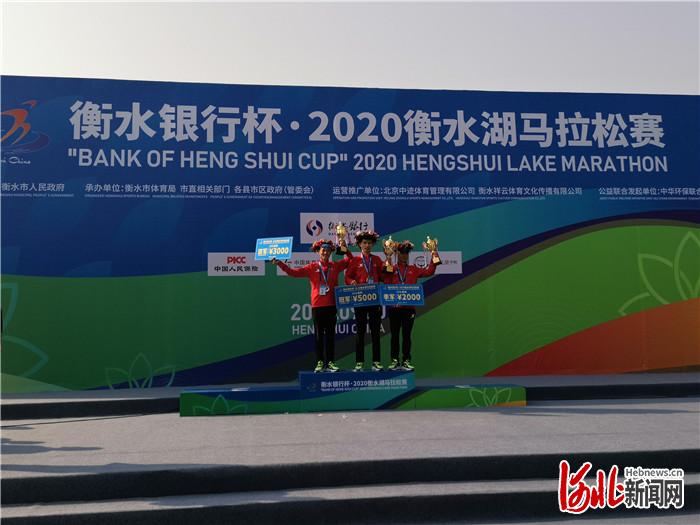 图为2020衡水湖马拉松赛10公里健康跑男子组前三名选手向观众挥舞奖杯。河北日报记者焦磊摄