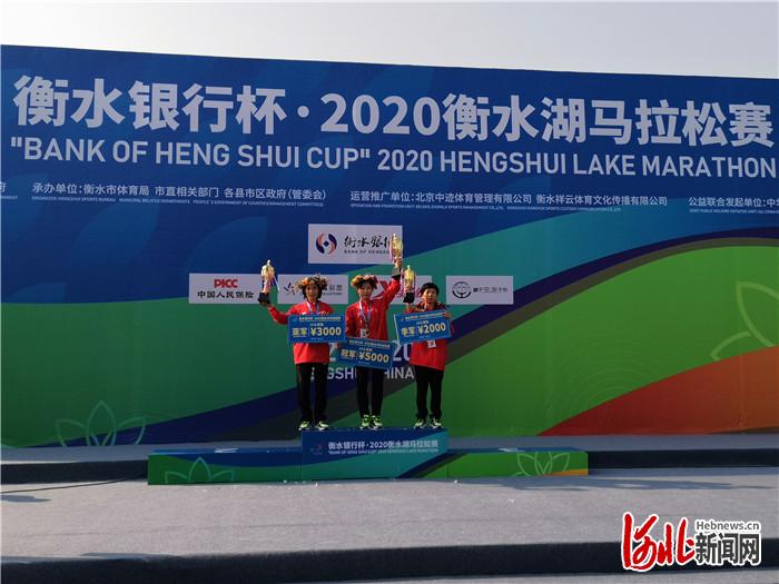 图为2020衡水湖马拉松赛10公里健康跑女子组前三名选手向观众挥舞奖杯。河北日报记者焦磊摄