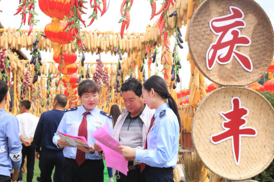 税务干部向前来参加丰收节的合作社负责人宣传税收政策