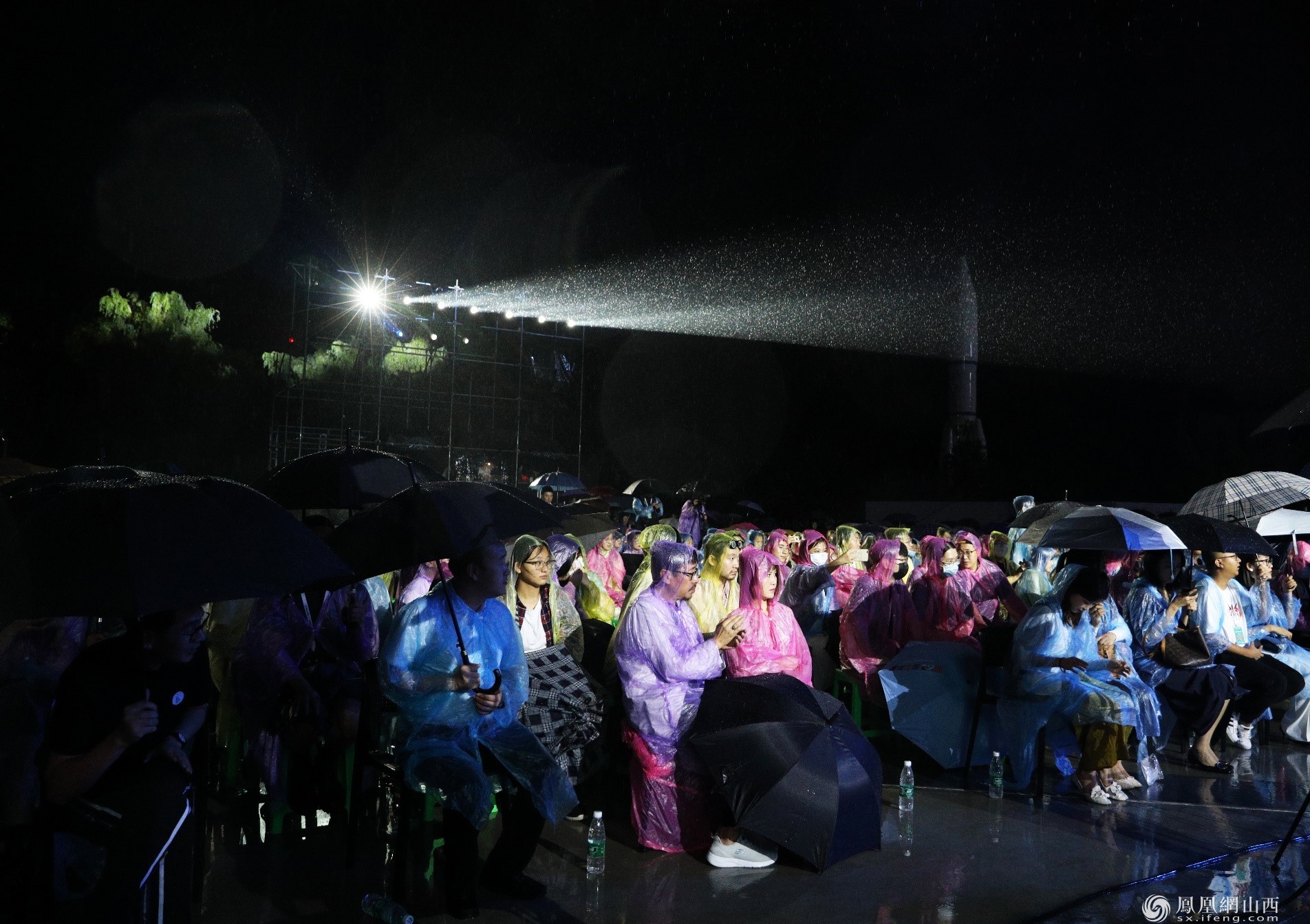 图为雨中的开幕式现场观众