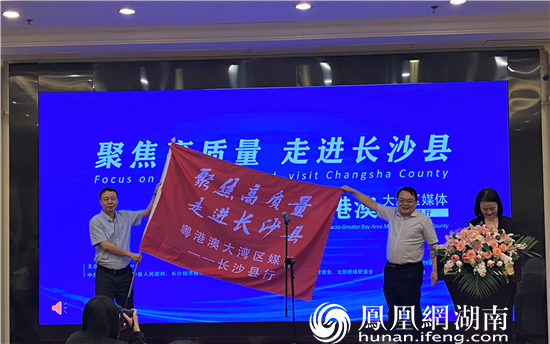 湖南省委网信办副主任屈贵全（右）为采访团代表凤凰网湖南站站长、董事长曾雪封（左）授旗。