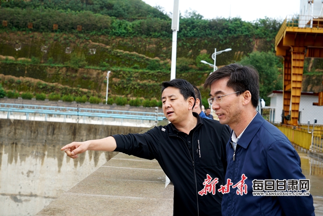 魏国梁(左)介绍水库情况