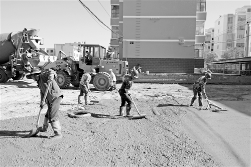 ▲近日，市住建局组织施工队伍对雄关六小区路面进行改造，进一步提升我市整体形象。 图为施工人员对小区路面进行改造 本报记者 雷昉谕 摄