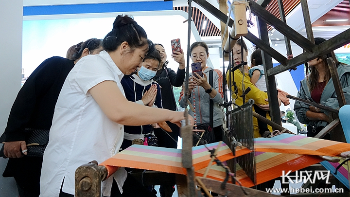在位于游客集散中心的展厅里，一台老织布机引得大家纷纷上前拍照。长城网记者 信贺宁 摄
