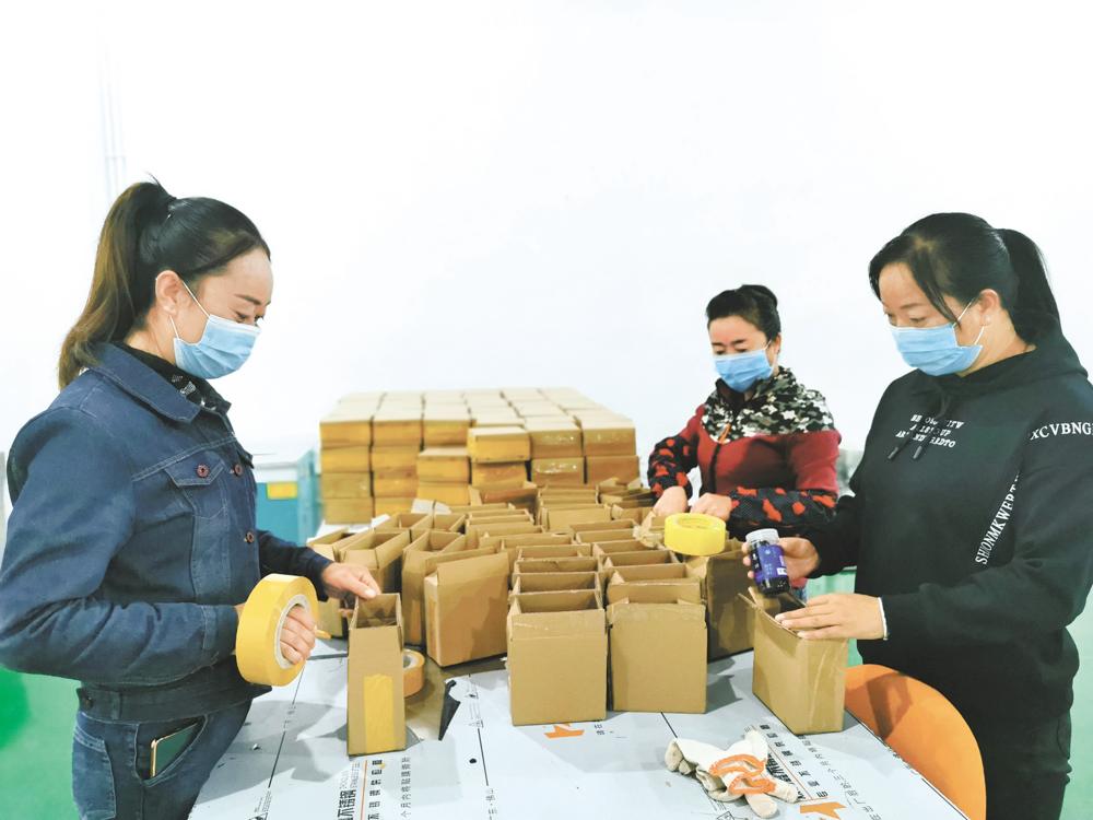 工人在电商物流车间包装商品