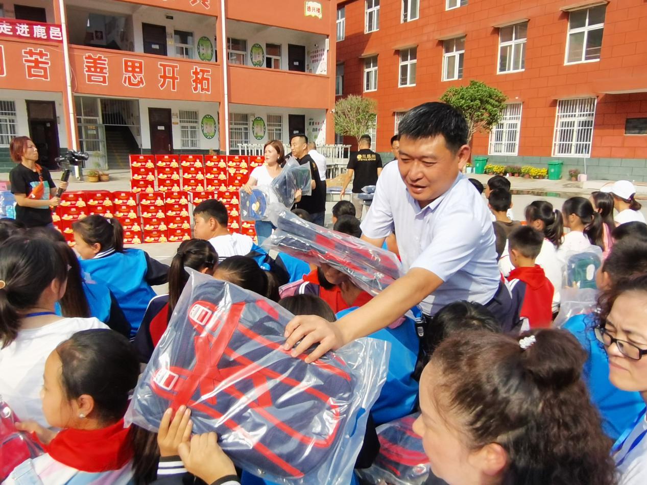 河南护理佳纸业有限公司董事长夏国印为孩子们分发书包
