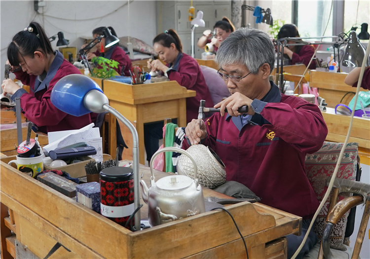10月6日，工人在遵化市马兰峪镇一家金属工艺品企业的银器錾雕车间工作。