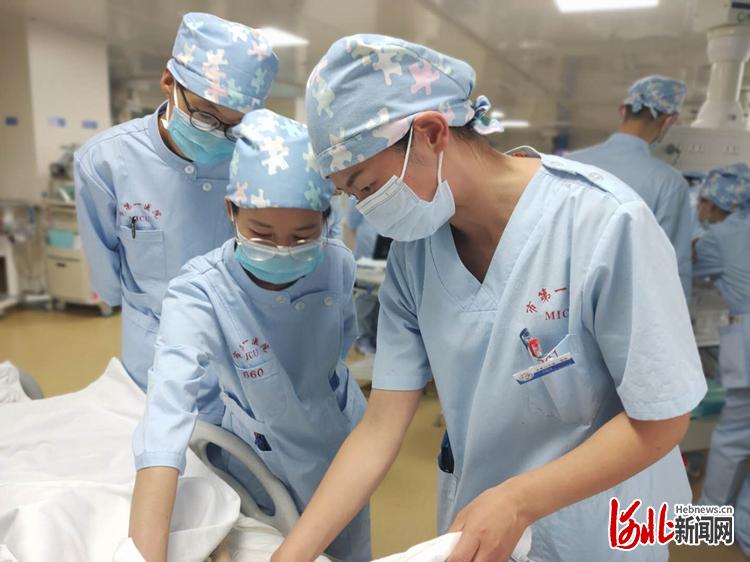 在重症医学科（内科）病房内，王晓芳（右一）在给护士讲解一些护理操作难点。 河北日报记者李艳红摄