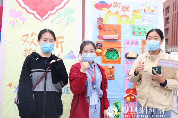 小学教育专业新生王晨妍（右）在学院手工制品前与志愿者合影