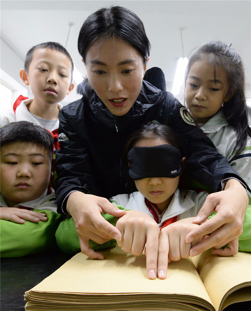 2020年10月14日，河北省邯郸市丛台区中华桥小学的学生在邯郸市特教中心老师的指导下“阅读”盲文书籍。