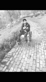 宋勇春坐在轮椅上晒太阳。图/受访者提供