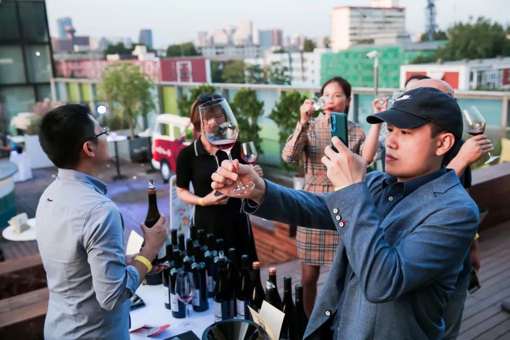 一边是酒商忙着讲酒,一边是现场来宾:自然酒的颜色都不一样呢(设计