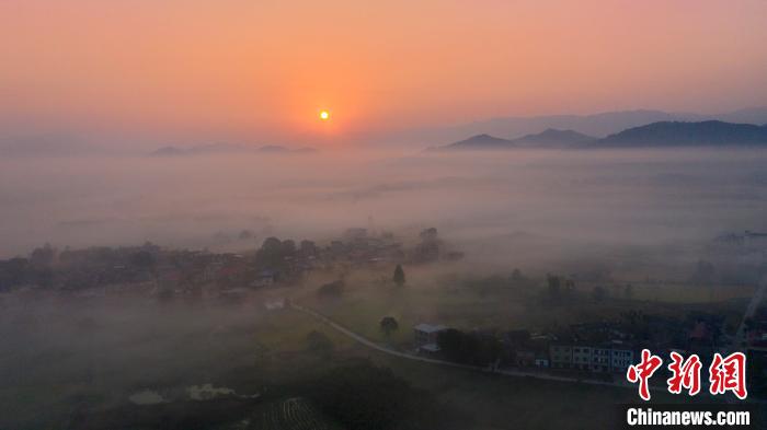 云雾缭绕的村庄与云海、日出勾勒出一幅美丽的日出画卷，美不胜收。　魏东升 摄