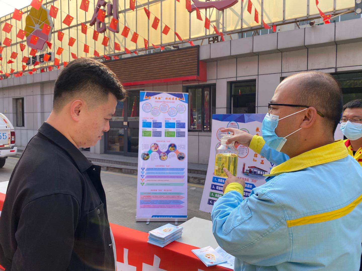 加油站工作人员为车主介绍油品质量