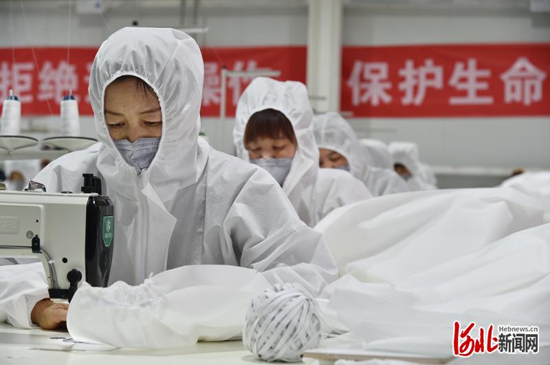 2月26日，河北省阜平县龙泉关镇平石头村手工扶贫车间内，工人们正在加紧生产一次性隔离服。 河北日报记者赵海江摄