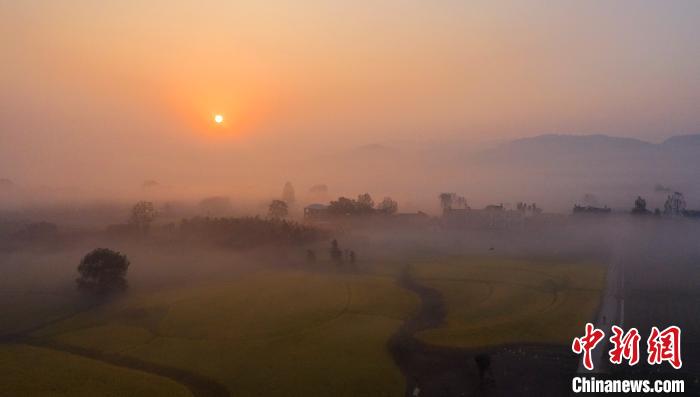 云雾缭绕的村庄与云海、日出勾勒出一幅美丽的日出画卷，美不胜收。　魏东升 摄