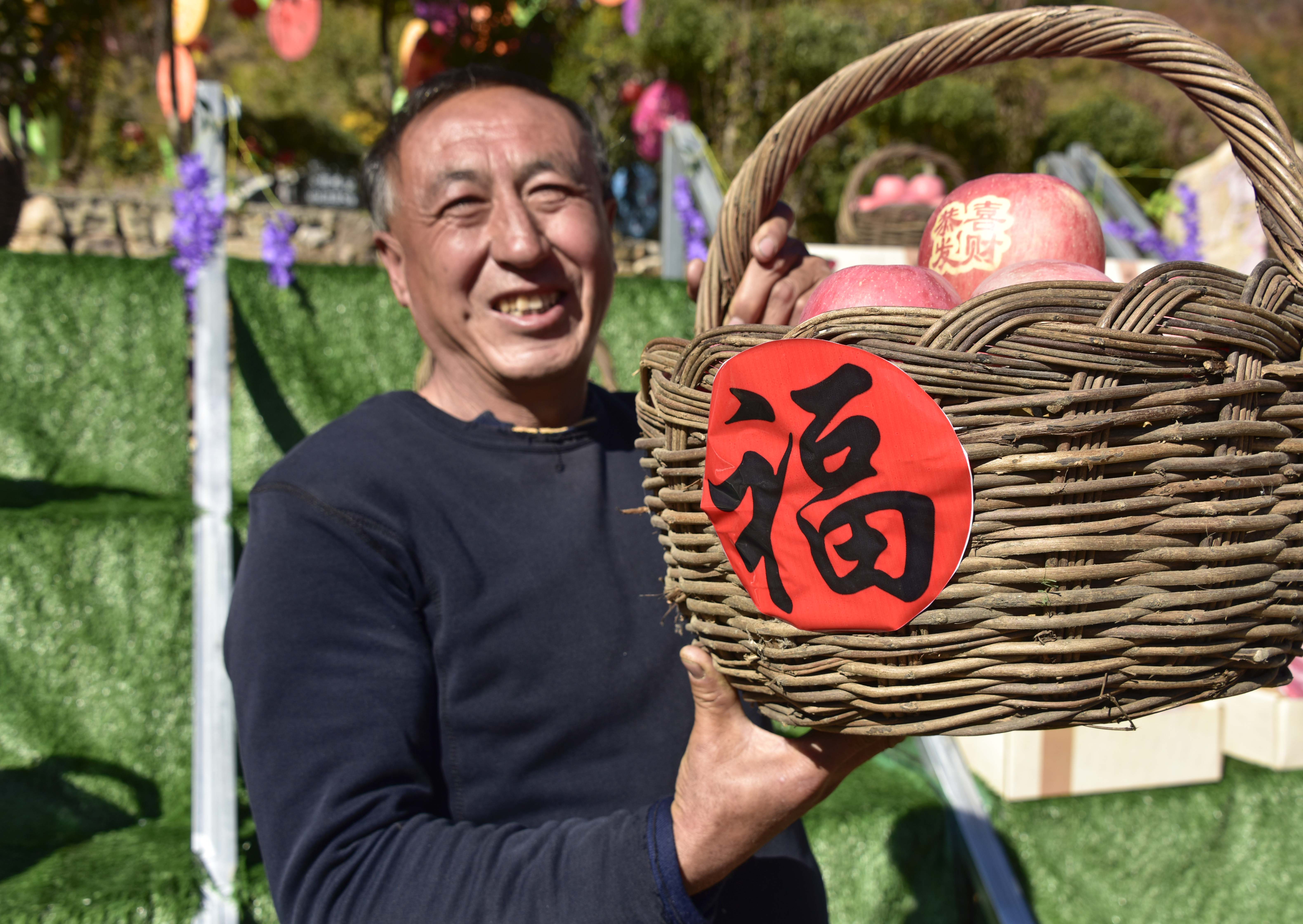 当地果农高兴地在苹果文化艺术节上展示自家的苹果 张旭 摄