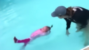 1岁女婴穿着衣服被教练推进泳池 结果令人意外