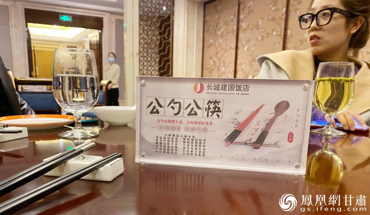 兰州建国饭店餐桌上摆放着"公筷公勺分餐夹"提示牌 南永涛 摄