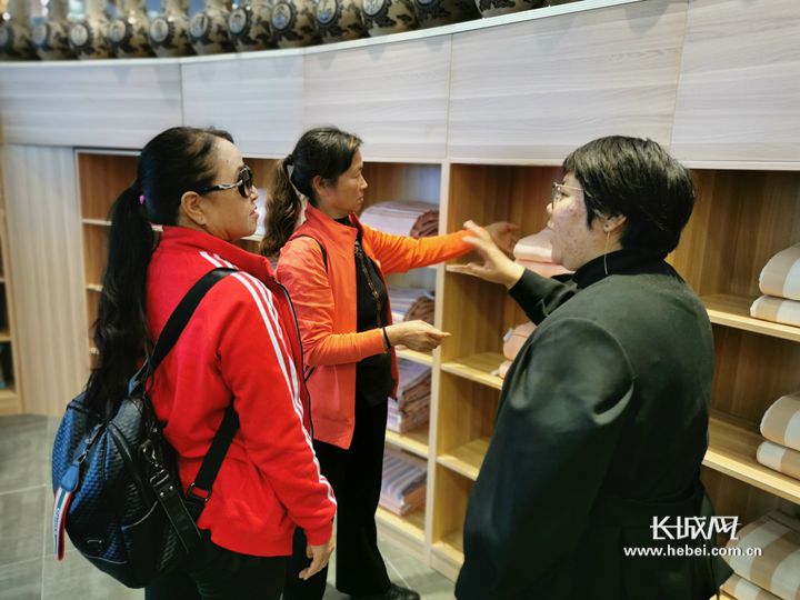 游客在原村土布博物馆挑选床品。长城网记者 胡晓梅 摄