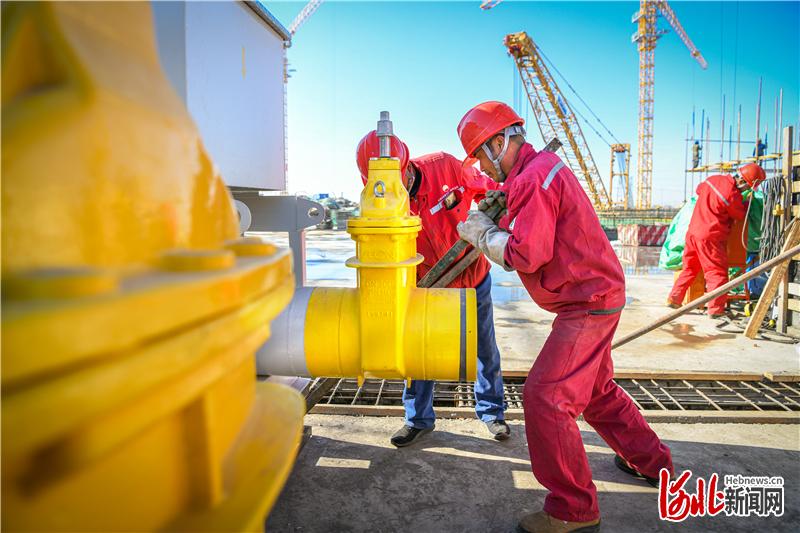 10月24日，高铁站片区供热(冷)工程1号能源站项目施工现场，工人在安装燃气管道阀门。通讯员任双欢摄