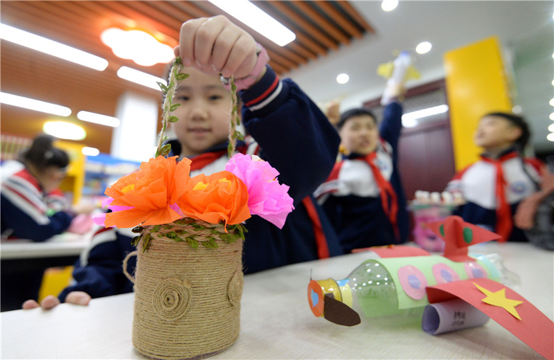 10月29日，河北省邯郸市邯山区实验小学的一名学生展示用废弃麻绳、彩纸等制作的“花篮”。