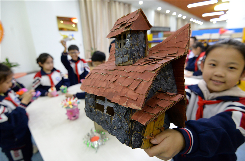 10月29日，河北省邯郸市邯山区实验小学的一名学生展示用废纸箱制作成的“石屋”。