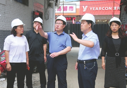 中阳县委副书记、县长田安平（左三）在城内幼儿园查看施工进度