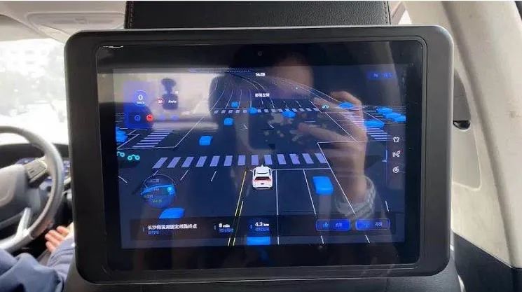 长沙街头的一台Robotaxi。汽车传感设备观察到的道路信息，以图像形式在电子屏上显示，便于体验自动驾驶的市民理解（图/张文婷）