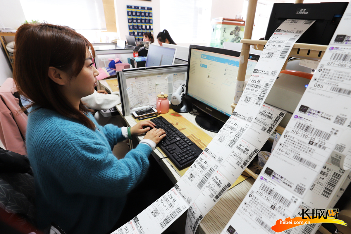 工作人员在唐山市玉田县鸦鸿桥镇一家企业内打印快递单据,准备发货