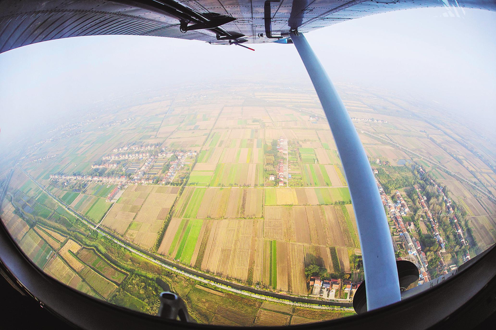 从飞机舷窗看到荆州江陵大片收割后的农田整齐排列。(湖北日报全媒记者 梅涛 摄)