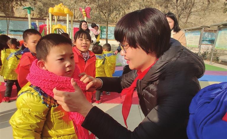 志愿者给孩子们戴上围巾